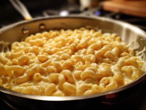 Close-up of creamy 3 ingredient stovetop mac and cheese in a stainless steel pan.