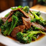 Close-up of tender slices of beef stir-fried with vibrant broccoli florets in a savory sauce.