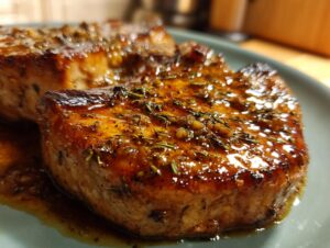 Close-up of juicy brown sugar garlic pork chops glazed with herbs and garlic.