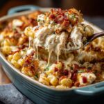 A spoonful of creamy Chicken Bacon Ranch Casserole with melted cheese, chicken, and crispy bacon.