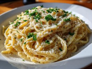 A close-up of a bowl of Creamy Lemon Pasta, topped with fresh parsley and grated Parmesan cheese.