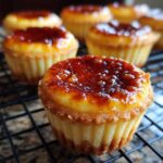 Close-up of a creme brulee cheesecake cupcake with a perfectly caramelized sugar topping.