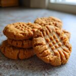 A stack of delicious peanut butter cookies with the classic criss-cross fork marks on top.