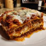 A hearty slice of slow cooker lasagna, featuring layers of pasta, rich meat sauce, and melted cheese.