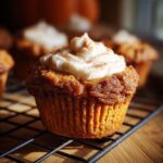 Close-up of a Starbucks pumpkin cream cheese muffin topped with cream cheese frosting and cinnamon.