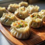 Close-up of steaming Traditional Chinese Dumplings filled with minced meat and vegetables on a wooden platter.
