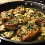 Close-up of Artichoke Chicken Piccata in a skillet, garnished with parsley and capers.