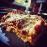 A delicious slice of Crockpot Ravioli Lasagna, showing layers of pasta, meat sauce, and melted cheese.