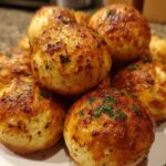 A close-up of golden-brown Garlic Parmesan Cheeseburger Bombs sprinkled with fresh parsley.