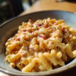 Close-up of creamy Rotel pasta with diced tomatoes and seasonings in a rustic bowl.