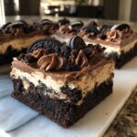 Close-up of a decadent slice of Slutty Brownies, featuring a brownie base, creamy filling, chocolate frosting, and Oreo cookies.
