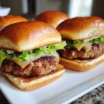 Close-up of two juicy turkey burger sliders with lettuce and cheese on a white plate.