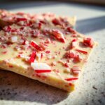 Close-up of a piece of white chocolate candy cane bark with crushed candy canes.