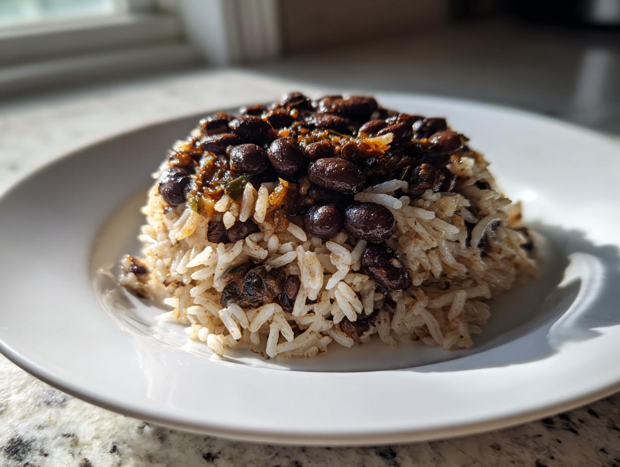 A mound of fluffy white rice topped generously with savory seasoned black beans and rice mixture.