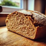 A close-up view showing the crumb texture of a freshly baked loaf of soda bread resting on a wooden cutting board.