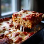 A gooey slice of lazy lasagna being lifted from the pan, showing incredible cheese pull.