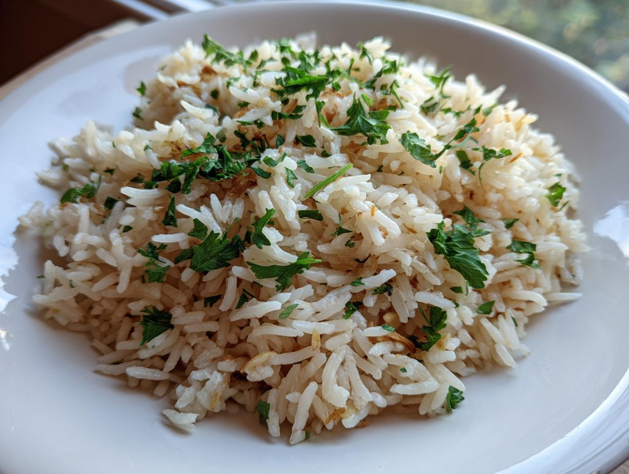 A close-up of a serving of fluffy rice pilaf recipe garnished generously with chopped fresh green parsley.