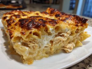 Close-up of a rich, cheesy slice of chicken lasagna with a deeply browned, bubbly top crust.