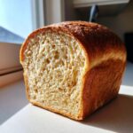 Close-up of a freshly baked whole wheat bread loaf showing its soft, airy interior crumb structure.