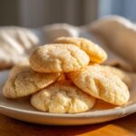 A warm, close-up stack of freshly baked butter cookie treats coated in sparkling sugar.
