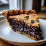 Close-up of a rich slice of hot fudge pie showing the dark, gooey chocolate filling and cookie crust.