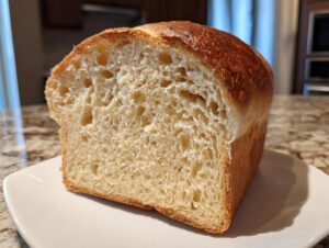 Close-up of the soft, open crumb structure of a freshly baked sourdough sandwich bread loaf.