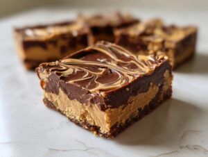 A close-up view of a thick, layered peanut butter bars square featuring a chocolate topping swirled with peanut butter.