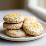 A stack of delicious earl grey cookies topped with white glaze, lemon drizzle, and bright yellow lemon zest.
