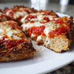 Close-up of cheesy slices made from the keto pizza crust recipe, showing a thick, golden-brown base.