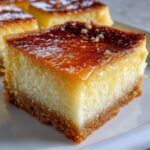 A close-up, mouthwatering shot of a square slice of cassava cake with a thick, glossy caramelized top.