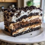 A decadent slice of layered dirt cake featuring chocolate pudding, cream, and crushed Oreo layers.