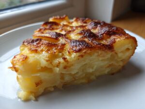 A thick slice of creamy potatoes au gratin showing layered potatoes and a deeply browned, cheesy top.