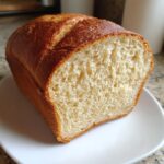 Close-up of a freshly baked loaf of amazing 1-hour gluten-free bread, showing a soft, light crumb and golden crust.
