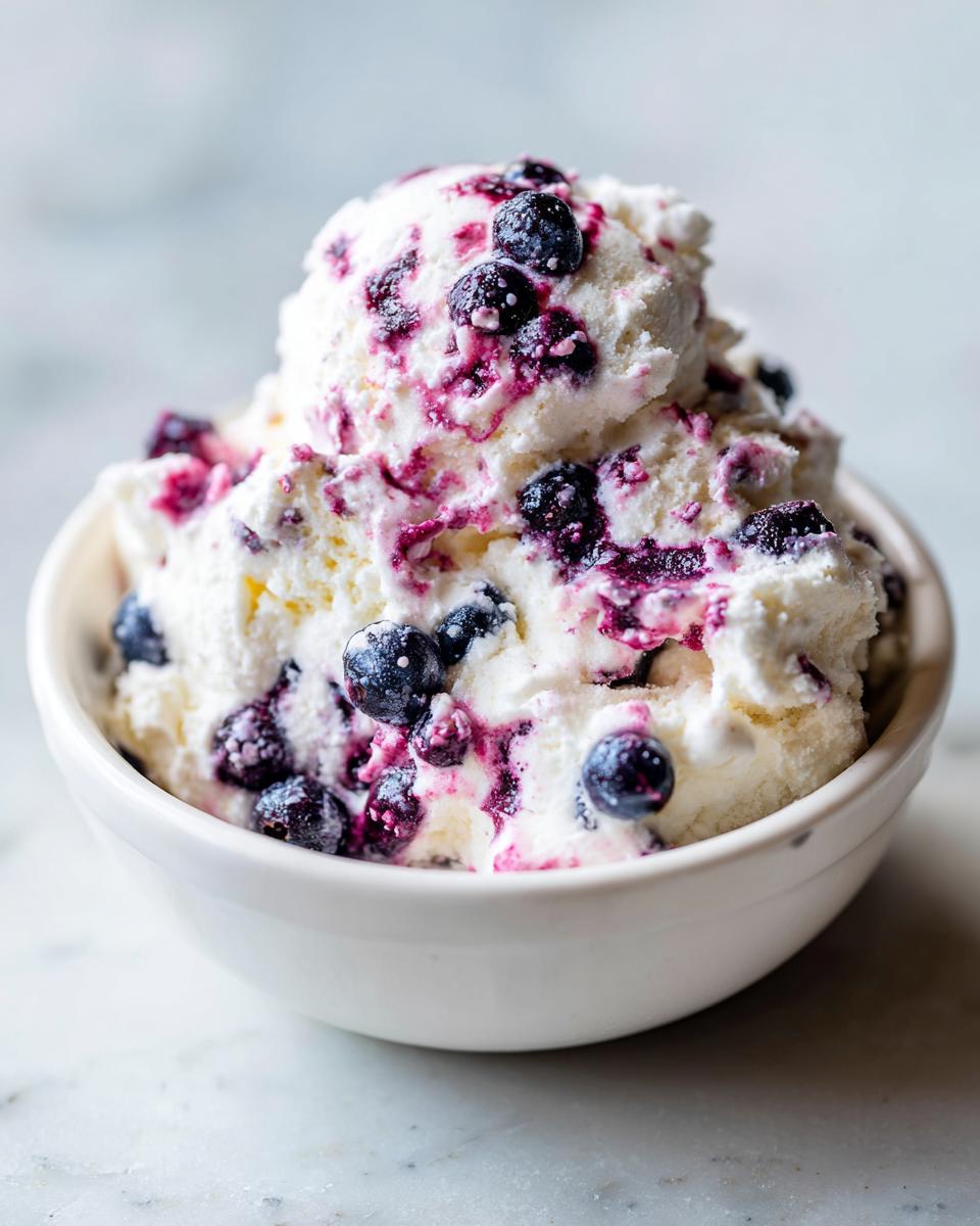 Close-up of creamy blueberry fluff salad with whole blueberries swirled throughout, served in a white bowl.
