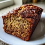 Close-up of a moist slice of snickerdoodle banana bread showing a rich, caramelized top crust.