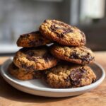 A tempting stack of freshly baked sourdough discard cookies and cream cookies piled on a white plate.