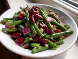Close-up of a vibrant three bean salad featuring green beans, kidney beans, and chickpeas mixed with red onion.