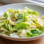Close-up of tender green cabbage coated in a creamy sauce, ready to eat Cabbage alfredo.