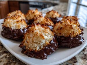 Close-up of several golden-brown Chocolate dipped macaroon cookies resting on a white serving plate.