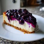 A perfect slice of No-bake blueberry cheesecake featuring a thick graham cracker crust and rich blueberry topping.