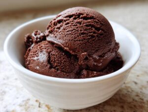 Two generous scoops of rich, dark No churn chocolate ice cream served in a small white bowl.