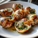 Close-up of several plump roasted escargot shells filled with bubbling garlic butter and fresh parsley.