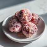 A small stack of frozen Strawberry yogurt bites coated heavily in sugar, resting on a white plate.